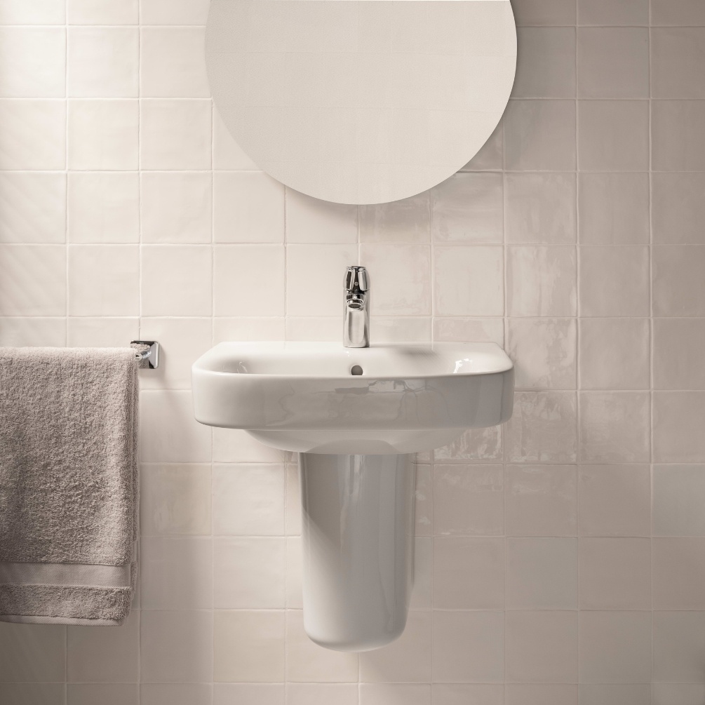 Lifestyle image of the Roca Debba 500mm Basin & Semi-Pedestal. Front-facing and mounted on a bathroom wall underneath a round mirror